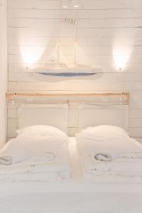 een bed met witte lakens en kussens in een kamer bij Romantic Stone House Double room in Kornić