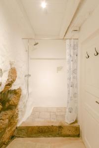 um chuveiro num quarto branco com uma porta em Romantic Stone House Double room em Kornic