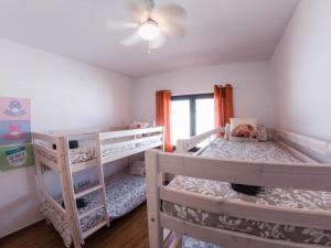 a bedroom with two bunk beds and a cat sitting on a chair at Villa Romans in Caleta De Fuste +32 photos