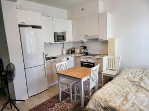 a kitchen with a table and chairs and a refrigerator at Apartment near the Harbour in Turku