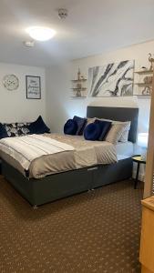 a bedroom with a large bed with blue pillows at Bv Homely Studio Fourteen At Deighton Huddersfield in Huddersfield