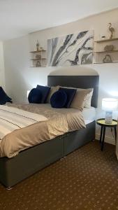a bedroom with a large bed with blue pillows at Bv Homely Studio Fourteen At Deighton Huddersfield in Huddersfield