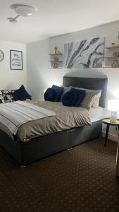 1 dormitorio con 1 cama grande con almohadas azules en Bv Homely Studio Fourteen At Deighton Huddersfield, en Huddersfield
