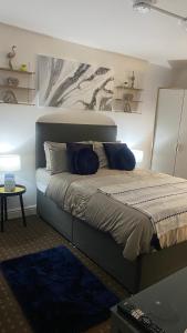 a bedroom with a large bed with blue pillows at Bv Homely Studio Fourteen At Deighton Huddersfield in Huddersfield