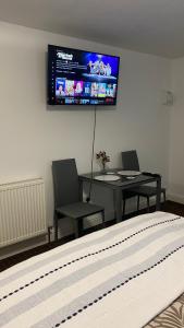 a bedroom with a table and a television on the wall at Bv Homely Studio Fourteen At Deighton Huddersfield in Huddersfield