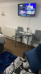 a room with a table and two chairs and a tv at Bv Homely Studio Fourteen At Deighton Huddersfield in Huddersfield