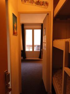 um corredor com uma porta que leva a um quarto com uma janela em Résidences de Mélisa La Foux d'Allos em La Foux