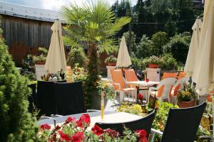 a patio with tables and chairs and umbrellas at Hotel Eder Michaela in Saalbach-Hinterglemm