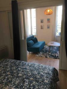 - une chambre avec un canapé bleu et une chaise dans l'établissement HYPER CENTRE CLIM T2 NEUF - OLD PORT 1.5KM, à Marseille
