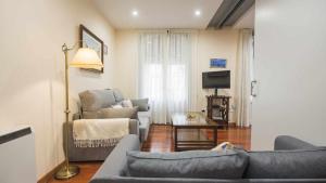 uma sala de estar com um sofá e cadeiras e uma televisão em La Balconada de la Plata by Toledo AP em Toledo