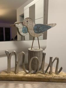 a wooden bird sitting on top of a wooden sign at Schillig, Nordsee - Friesland - Wohnung - neu in Wangerland