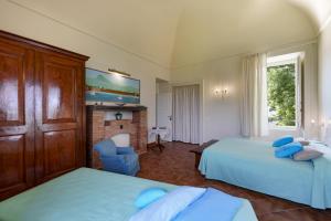 a hotel room with two beds with blue pillows at Villa Preziosa al Pizzo 3 km da Sorrento in Sant'Agnello
