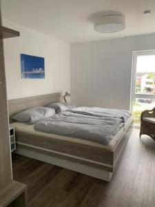 1 cama en una habitación con ventana en Schillig, Nordsee - Friesland - Wohnung - neu en Wangerland