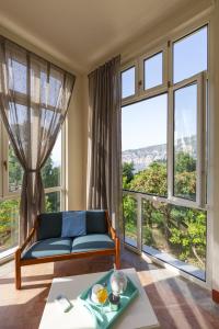 sala de estar con sofá azul y ventanas grandes en Villa Preziosa al Pizzo 3 km da Sorrento en Sant'Agnello