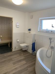 y baño con bañera, aseo y lavamanos. en Schillig, Nordsee - Friesland - Wohnung - neu en Wangerland