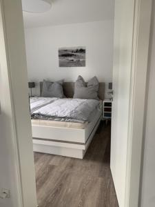 1 dormitorio con 1 cama en una habitación blanca en Schillig, Nordsee - Friesland - Wohnung - neu en Wangerland