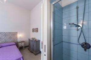 1 dormitorio con ducha y pared de azulejos azules en Villa Preziosa al Pizzo 3 km da Sorrento en Sant'Agnello