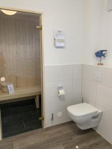 ein Bad mit einem WC und einer Dusche in der Unterkunft Schillig, Nordsee - Friesland - Wohnung - neu in Wangerland