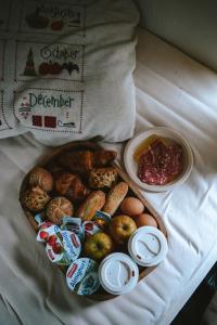 een dienblad met verschillende soorten ontbijtproducten op een bed bij Slaapwagen Veldzicht in Papenvoort