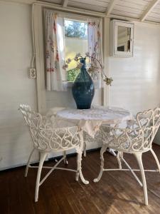 a table and two chairs with a vase on it at Slaapwagen Veldzicht in Papenvoort