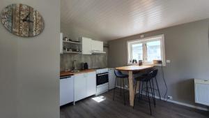 uma cozinha com uma mesa e algumas cadeiras em Kaikanten Kro og Rorbu em Sennesvik