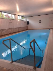 a large blue swimming pool in a building at Appartement Wettersteinblick mit Sauna und Pool in Seefeld in Tirol +15 photos