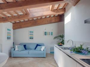 a kitchen and living room with a blue couch at Rambaldi Apartments Casa nr 5 in Bardolino