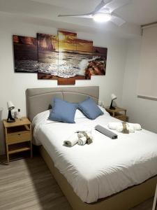 a bedroom with a white bed with blue pillows at Octopus´Garden in La Herradura