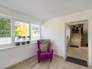 un soggiorno con una sedia viola e finestre di Apartment Weberbauer-2 by Interhome a Hollersbach im Pinzgau