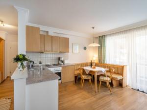 una cucina e una sala da pranzo con tavolo e sedie di Apartment Weberbauer-3 by Interhome a Hollersbach im Pinzgau