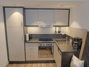eine kleine Küche mit weißen Schränken und einer Spüle in der Unterkunft Apartment Leiter-2 by Interhome in Sölden