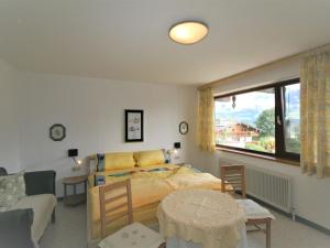 a bedroom with a bed and a table and a couch at Apartment Höllwarth by Interhome in Fügenberg