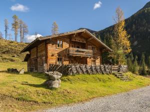a log cabin on a hill in the mountains at Chalet Gnadenalm - OBR103 by Interhome in Obertauern