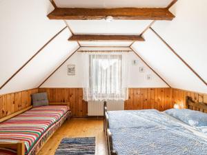 two beds in a attic bedroom with a window at Holiday Home Richter by Interhome in Zistl