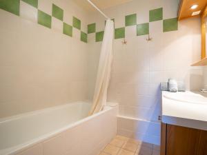 a bathroom with a tub and a sink and a bath tubermottermott at Apartment Origanes 226 by Interhome in Les Menuires