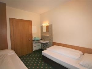 une chambre d'hôtel avec deux lits et un lavabo dans l'établissement Apartment Rauter-1 by Interhome, à Mayrhofen