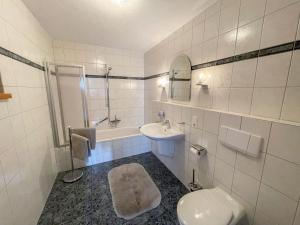 a white bathroom with a toilet and a sink at Apartment Janik by Interhome in Bischofsmais