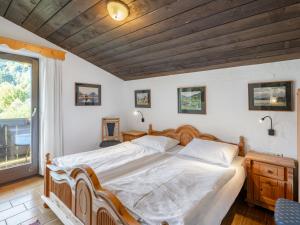 ein Schlafzimmer mit einem großen Bett und einem Fenster in der Unterkunft Apartment Kitzsteinhorn by Interhome in Winklerdörfl