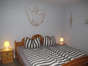 a bed with black and white pillows and two lamps at Holiday Home Ostwind by Interhome in Ummanz