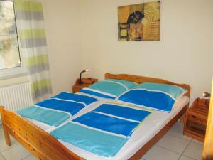 a bed with blue pillows on it in a bedroom at Holiday Home Lenzer Höh-2 by Interhome in Lenz