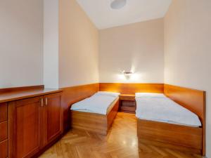 two beds in a room with wooden cabinets at Apartment Base Camp 1 by Interhome in Desná