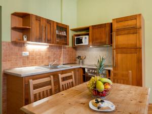 uma cozinha com uma mesa de madeira e uma taça de fruta em Apartment Base Camp 2 by Interhome em Desná
