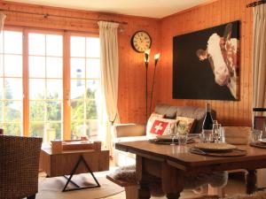 a living room with a table and a clock on the wall at Apartment Armorial II - apt 2 by Interhome in Villars-sur-Ollon