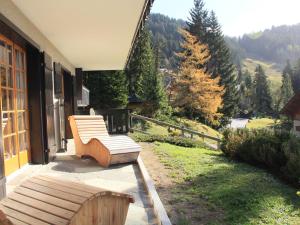 a wooden bench sitting on the porch of a house at Apartment Armorial II - apt 2 by Interhome in Villars-sur-Ollon