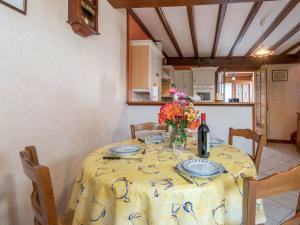 ein Tisch mit einer gelben Tischdecke und einer Flasche Wein in der Unterkunft Holiday Home Tytisa N-2 by Interhome in Barneville-Carteret