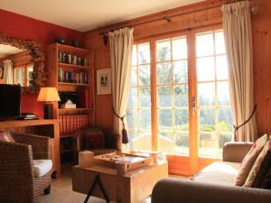 a living room with a couch and a large window at Apartment Armorial II - apt 2 by Interhome in Villars-sur-Ollon