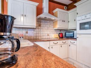 eine Küche mit weißen Schränken und einer Granitarbeitsplatte in der Unterkunft Holiday Home Tytisa N-2 by Interhome in Barneville-Carteret + 16 Fotos