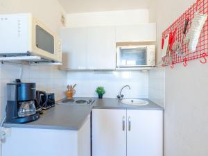 サント・マキシムにあるApartment Régina-2 by Interhomeの白いキャビネットとシンク付きのキッチン