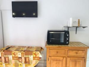 a microwave sitting on top of a wooden cabinet at Apartment Amourêva-1 by Interhome in Cap d'Agde