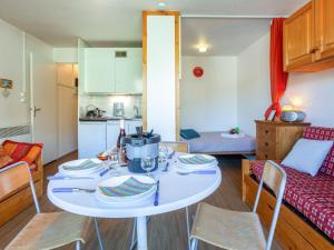 a kitchen and living room with a white table and chairs at Studio Vostok Zodiaque-42 by Interhome in Le Corbier